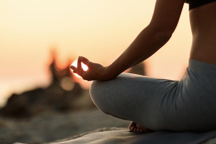 cerrar mujer meditando posición de loto atardecer